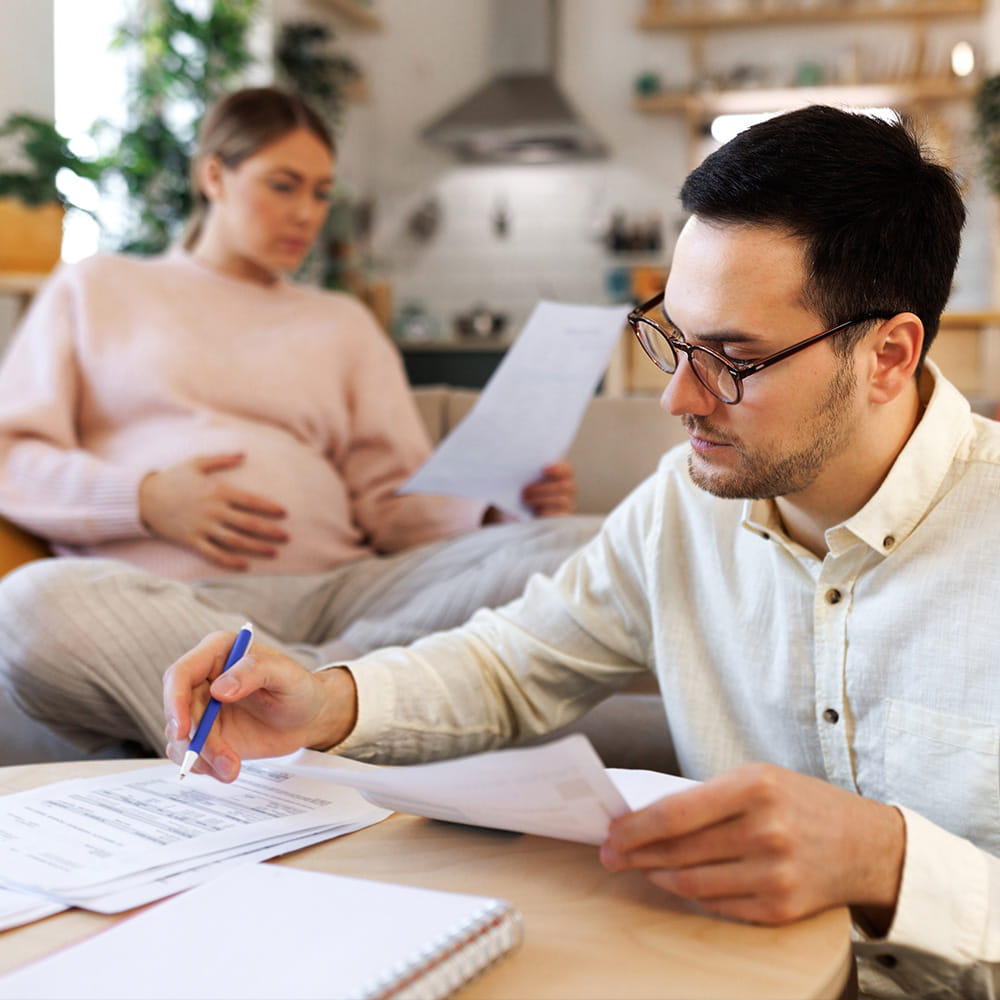 pregnant couple looking at household finances